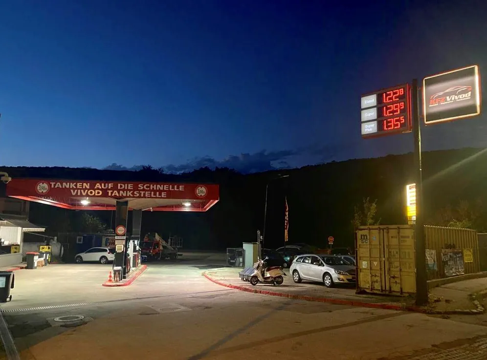 Tankstelle in der Dämmerung mit beleuchtetem Dach